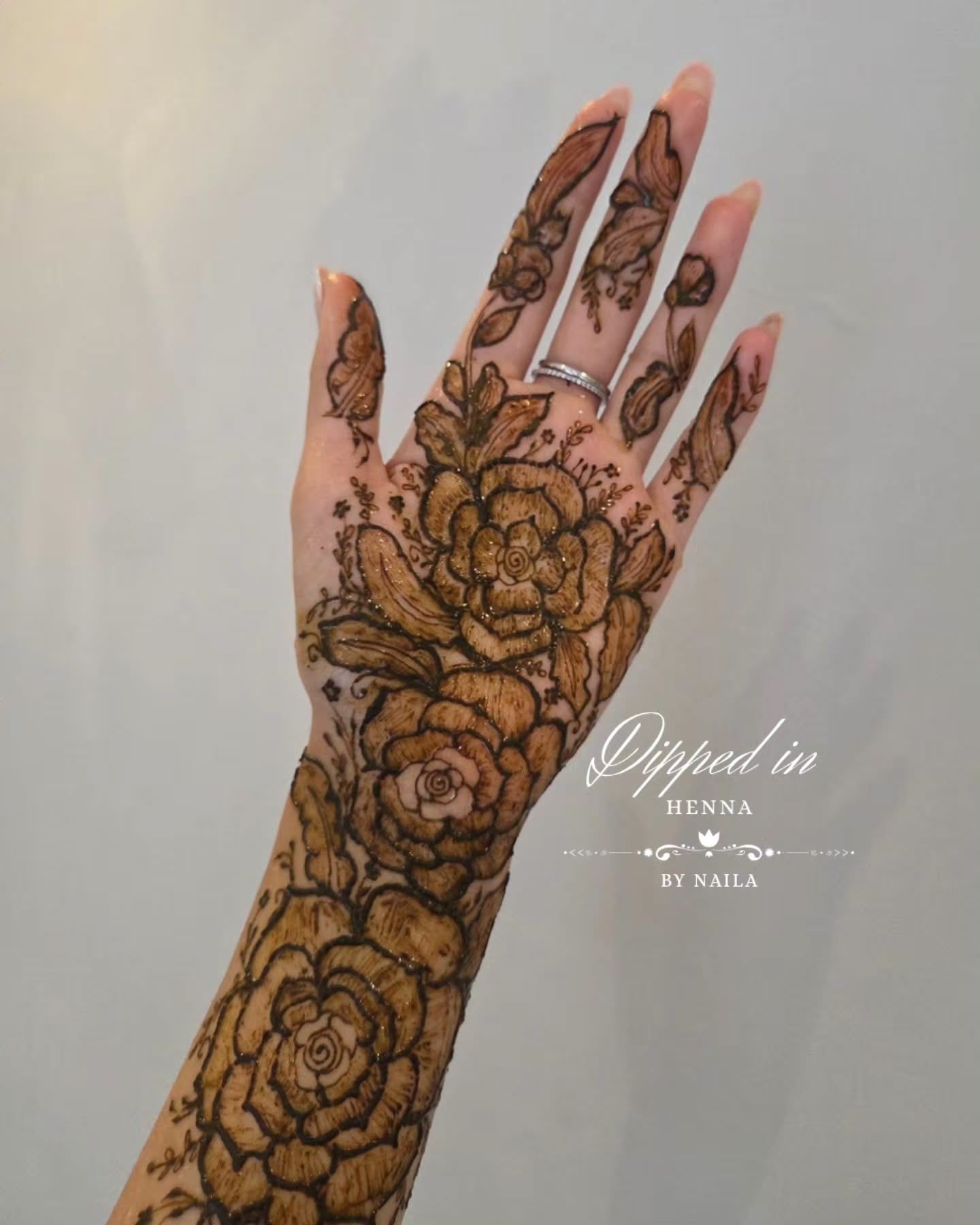 Large roses in henna across the hand
